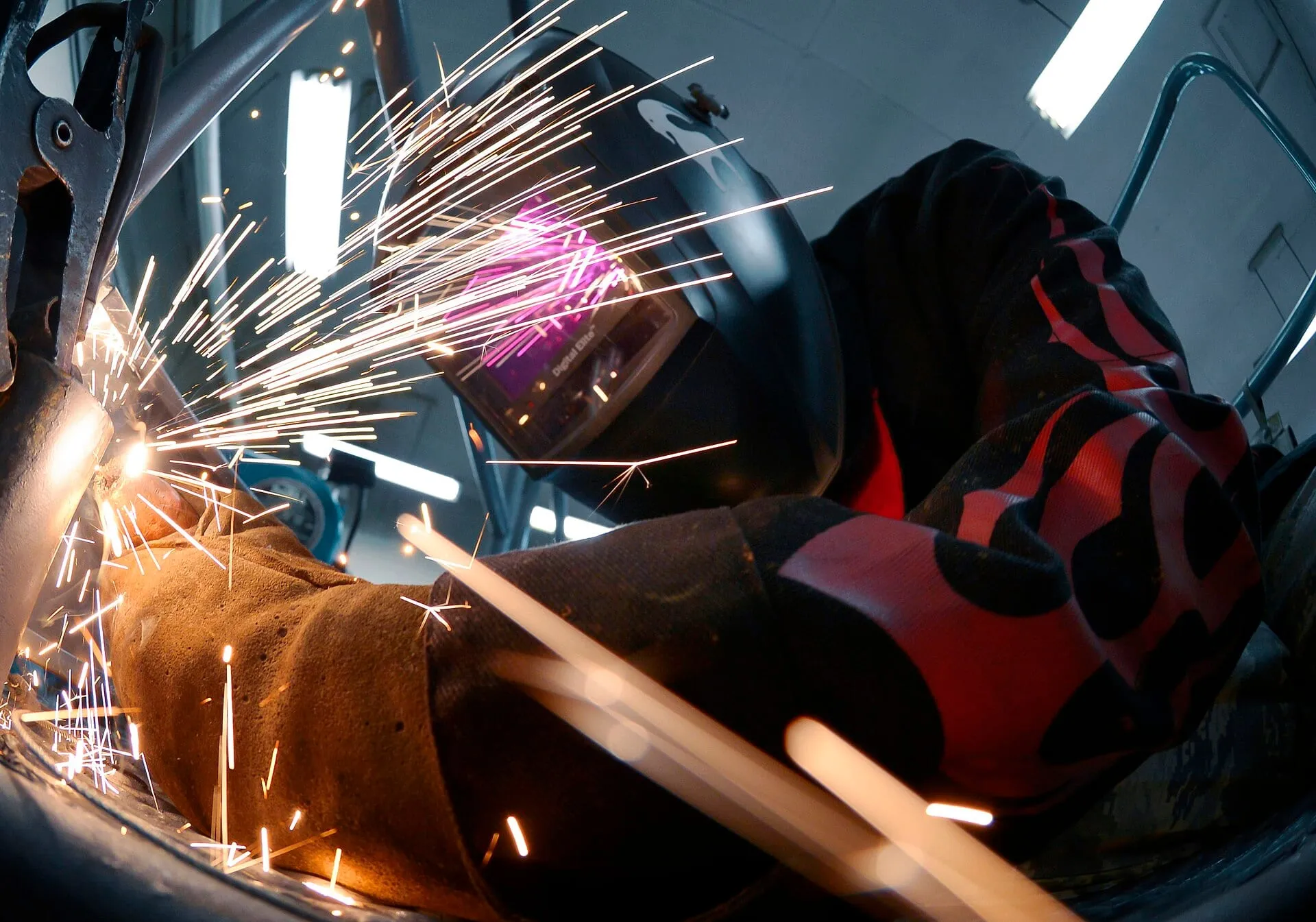 Welder at work, sparks across the workpiece